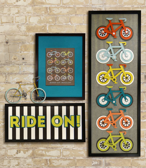 framed bicycle themed artwork on a brick wall