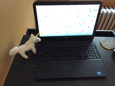 stuffed unicorn next to a laptop