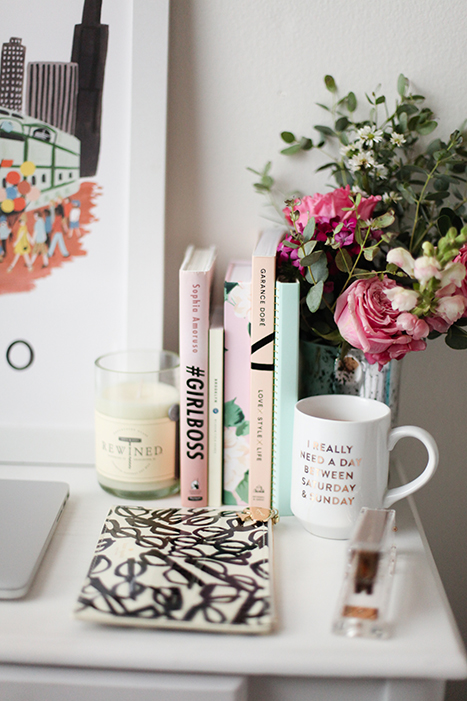 books lined up with a vase of flowers