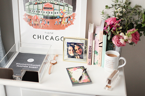 desk with supplies, flowers, and a picture of Chicago on it